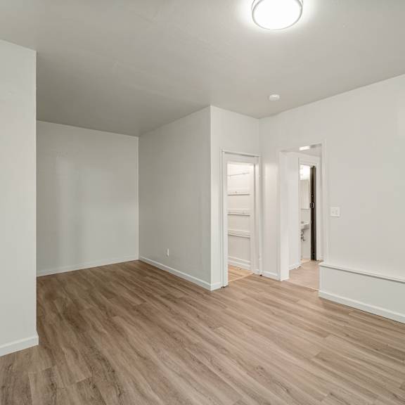 a room with white walls and wooden flooring.