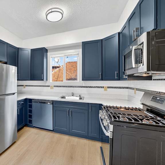 a kitchen with a stainless steel refrigerator and dark blue cabinets.