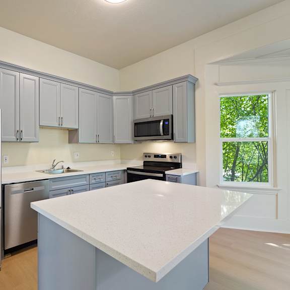 a kitchen with a refrigerator, microwave, and oven.