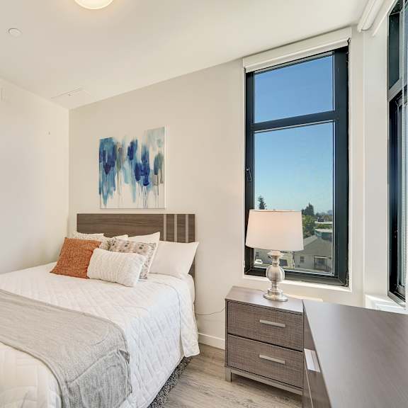 a bedroom with a large bed and a painting on the wall.