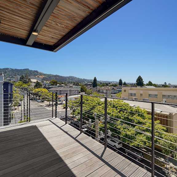a balcony with a railing overlooks a town.