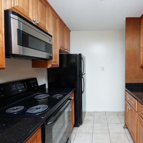 a kitchen with black appliances and wooden cabinets.