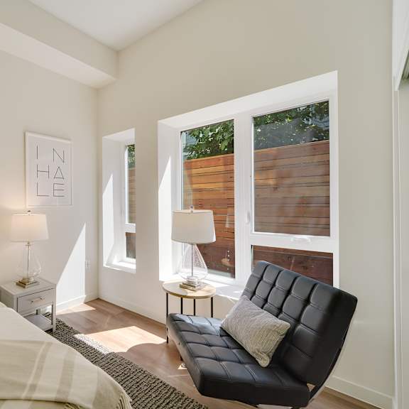 a bedroom with a bed, a chair, and two lamps.