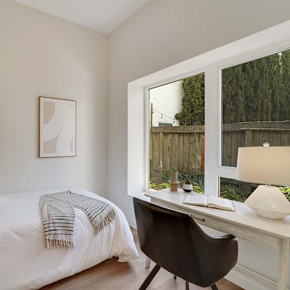 a bedroom with a bed, desk, and chair.