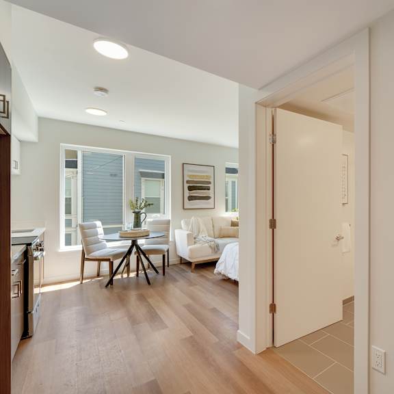 a modern kitchen with a dining table and chairs in the background.