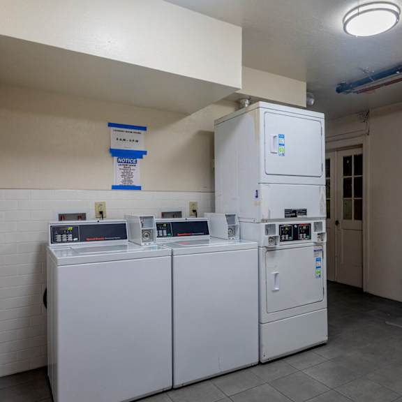 a laundry room with two washes and two refrigerators in it