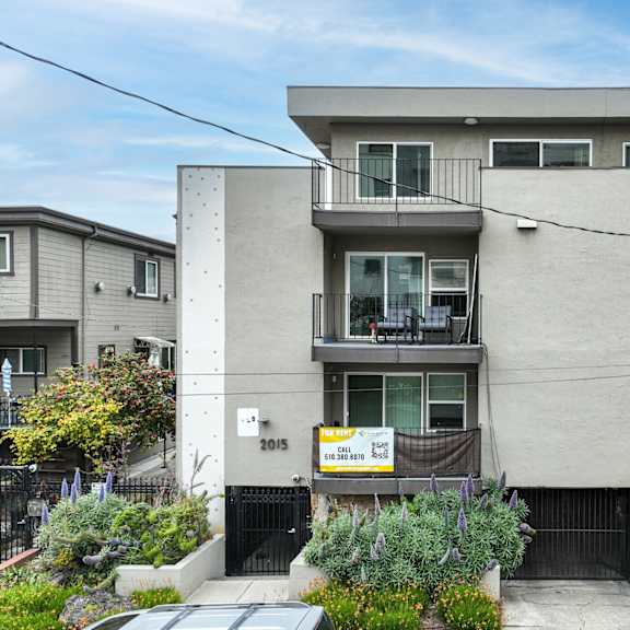 a modern two-story house with a balcony on the second floor.