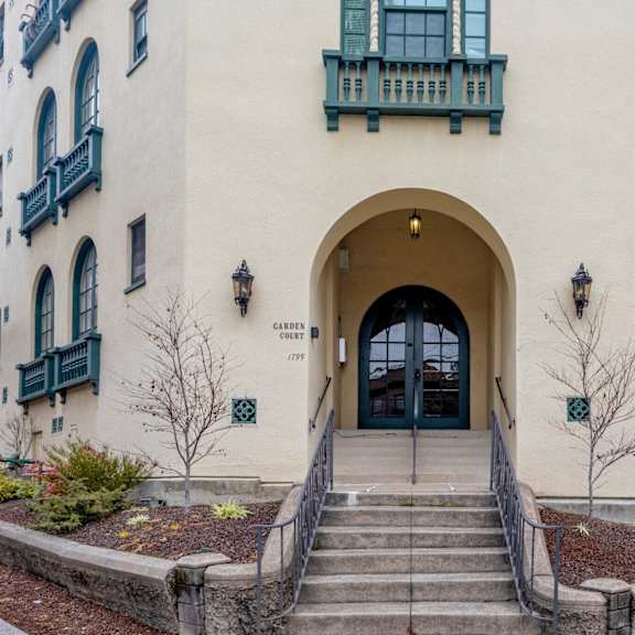 the front of a building with stairs and a large arched doorway
