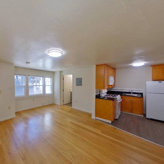 a kitchen with wooden floors and white walls.