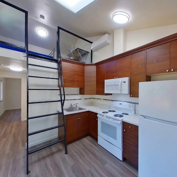 a kitchen with white appliances and wooden cabinets.