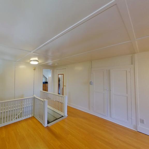 a room with wooden floors and white walls.