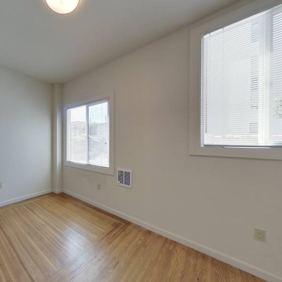 empty room with wooden floor and white walls.