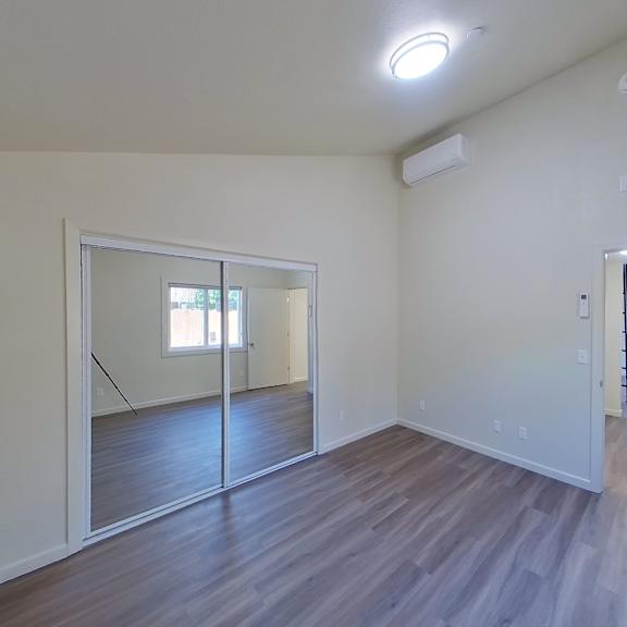 a room with a mirror and wooden flooring.