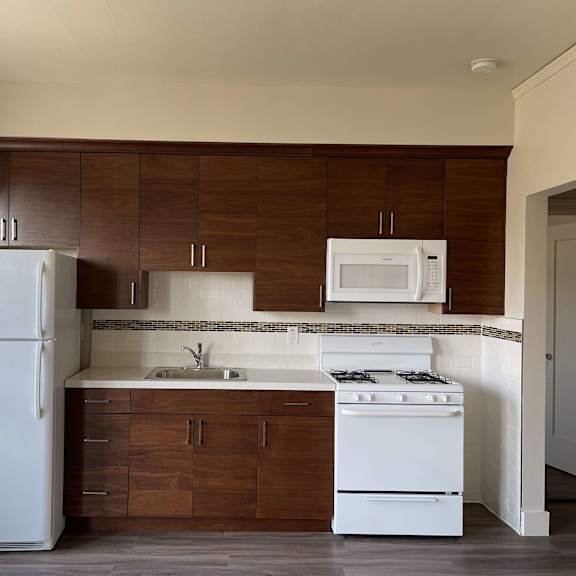 a small kitchen with white appliances and wooden cabinets
