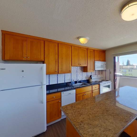 a kitchen with a refrigerator, stove, and sink.