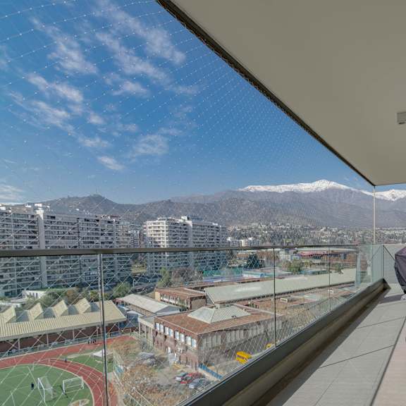 a balcony with a chair and a view of a city and mountains.