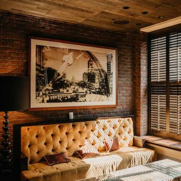 a room with a tufted sofa and a framed picture on the wall.