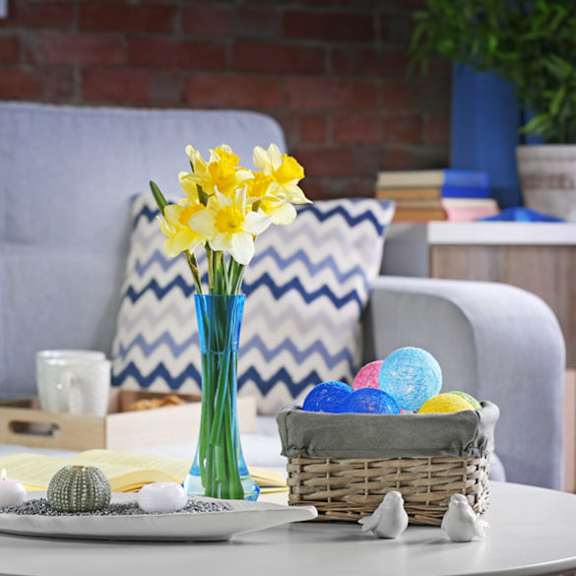 a table with a vase of flowers and eggs on it
