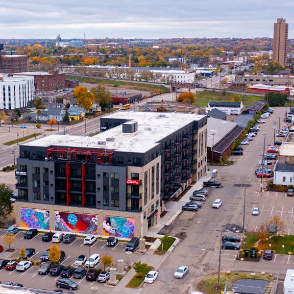 an aerial view of a city with a building and parking lot