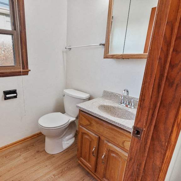 a bathroom with a toilet and a sink and a window