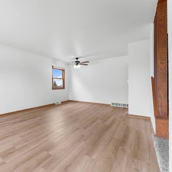 a room with wooden flooring and a ceiling fan.
