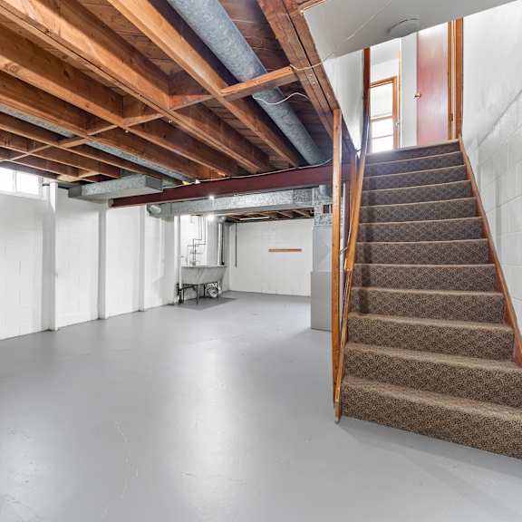 a room with a staircase and a white wall.