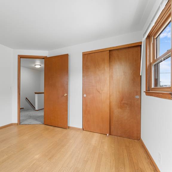 a room with wooden floors and two wooden doors.
