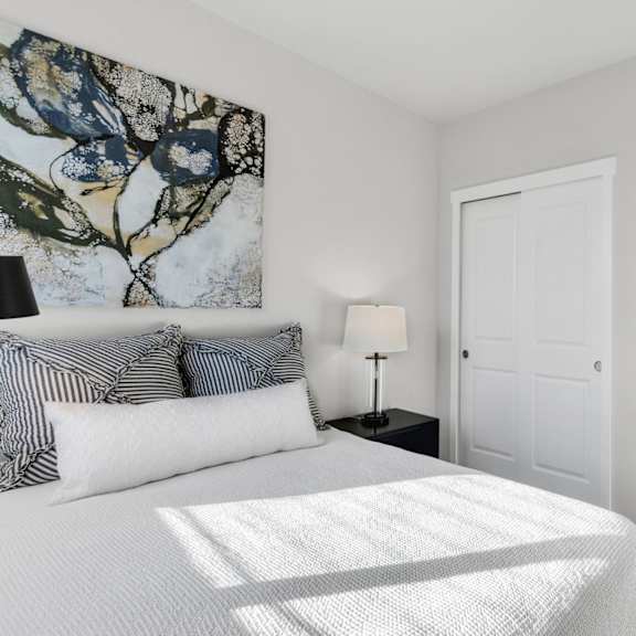 a bedroom with a large bed and a painting on the wall.
