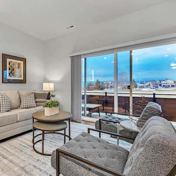 a living room with a couch, a chair, a table, and a floor lamp.