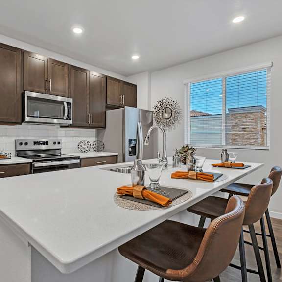 a kitchen with brown cabinets and a white island.
