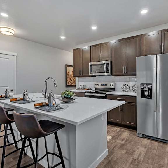 a modern kitchen with a white countertop and a stainless steel refrigerator.