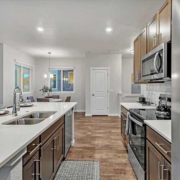a modern kitchen with stainless steel appliances and wooden cabinets.
