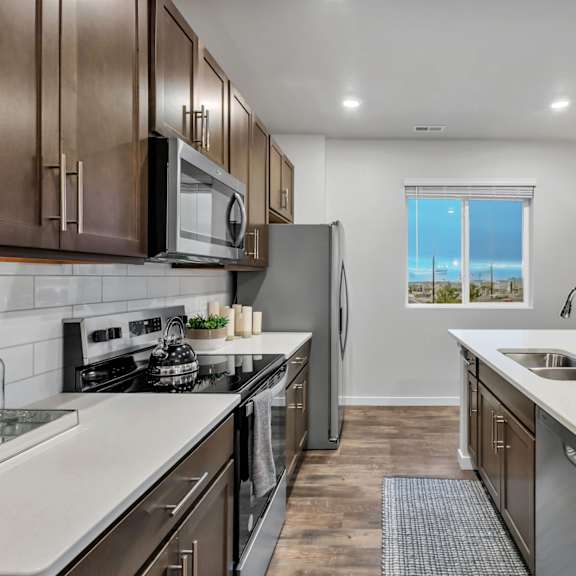 a modern kitchen with stainless steel appliances and wooden cabinets.