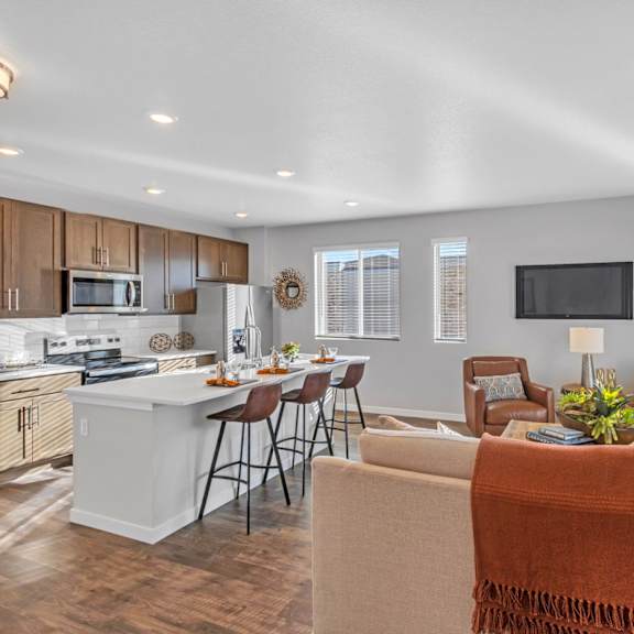 a modern kitchen with a breakfast bar and a couch with a blanket on it.