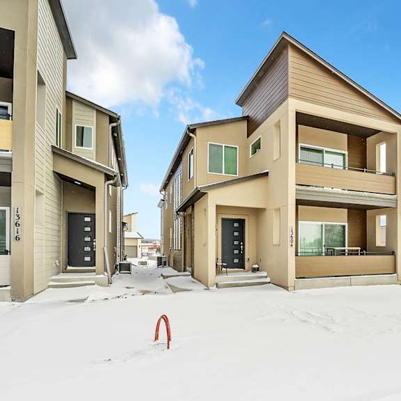 a row of houses with snow on the ground.