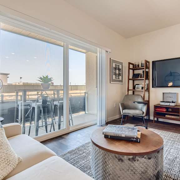 a living room with a couch and a tv and a balcony