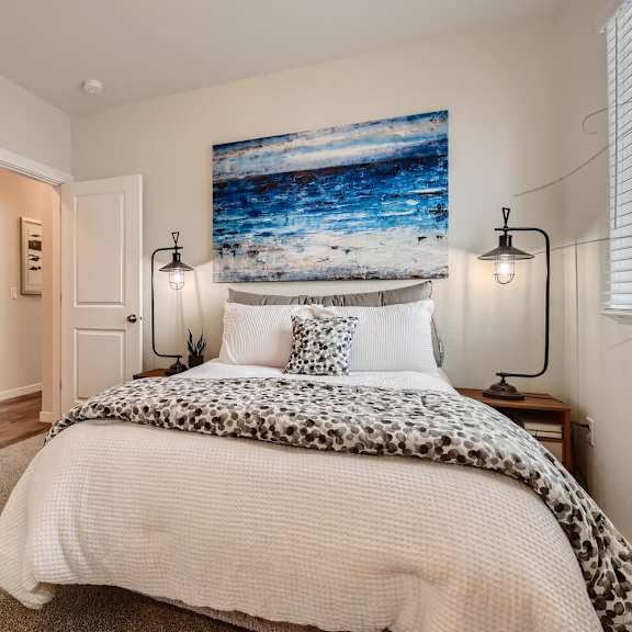 a bedroom with a bed and a painting on the wall
