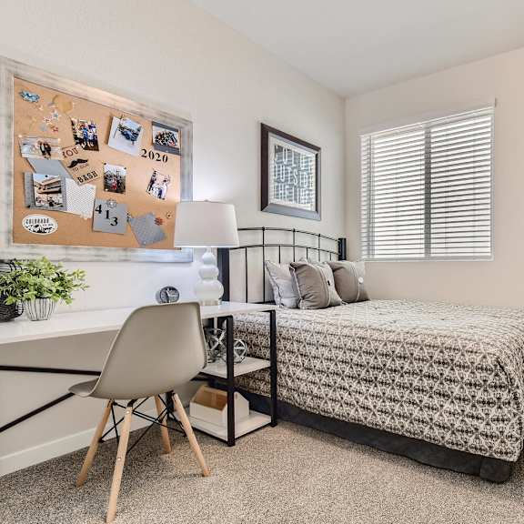 a bedroom with a bed and a desk with a chair
