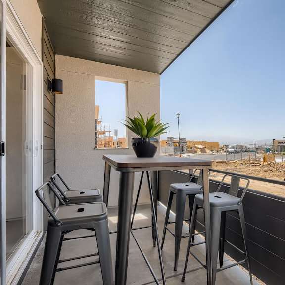 a bar with stools and a table on a balcony with a view