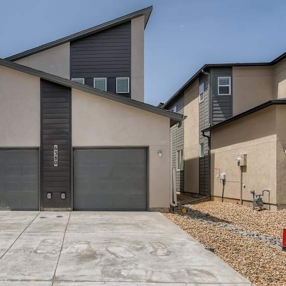 the front of a building with two garage doors