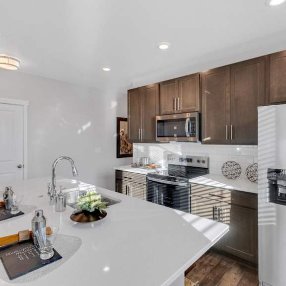 a modern kitchen with a white countertop and stainless steel appliances.