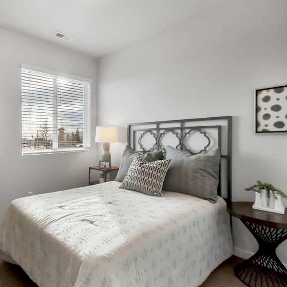 a bedroom with a large bed, a small table, and a painting on the wall.