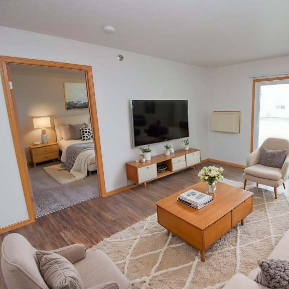 a living room with a grey couch and a wooden coffee table.