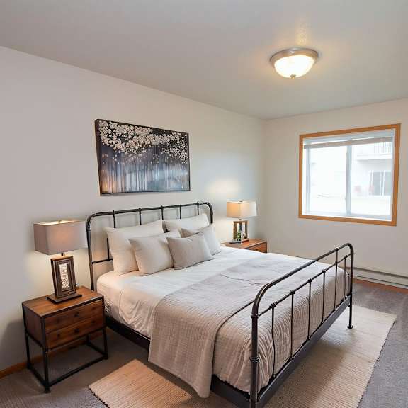 a bedroom with a bed, nightstands, and a window.