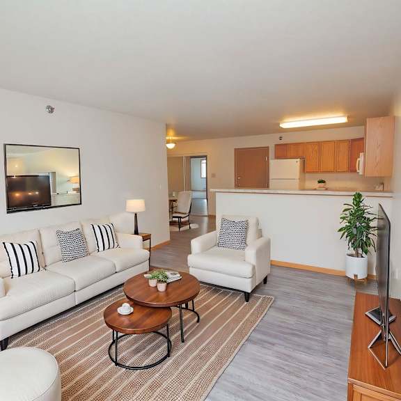 a living room with a white couch, a coffee table, and a lamp.