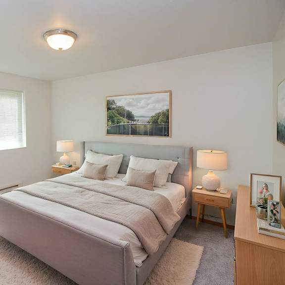a bedroom with a large bed and a potted plant.
