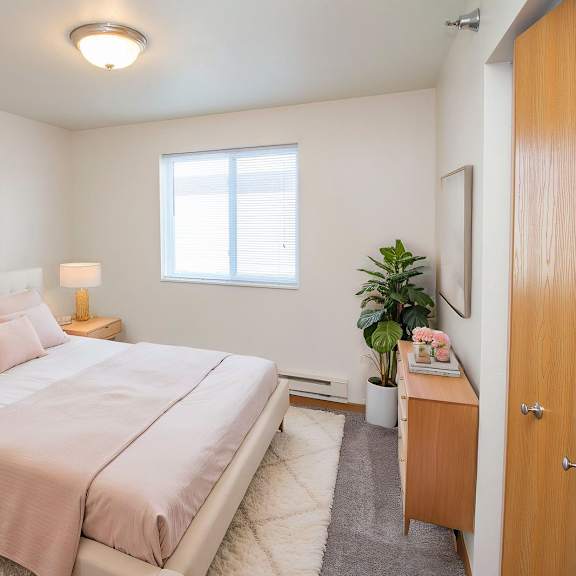 a bedroom with a bed, nightstand, and lamp.