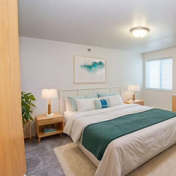 a bedroom with a large bed, a chair, and a painting on the wall.