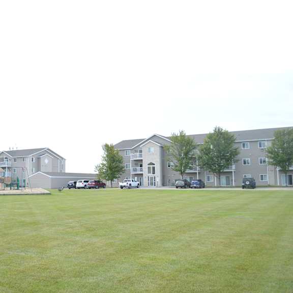 apartment complex with a green lawn in front.