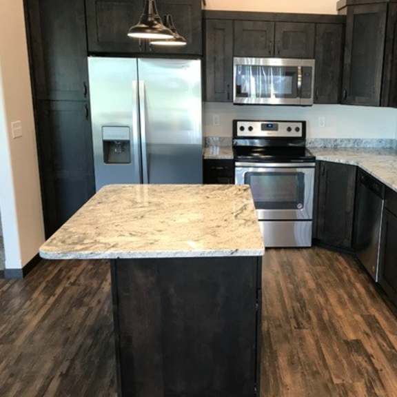 a kitchen with a granite countertop and stainless steel appliances.